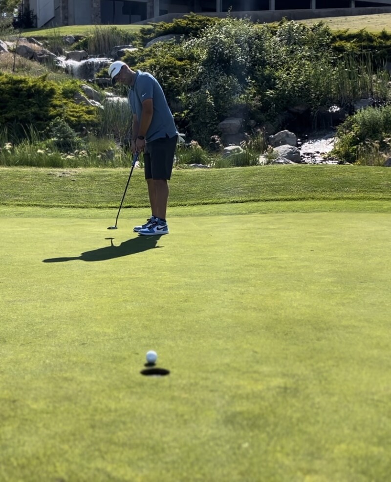 Coach Mike Yates watching a shot on the golf course