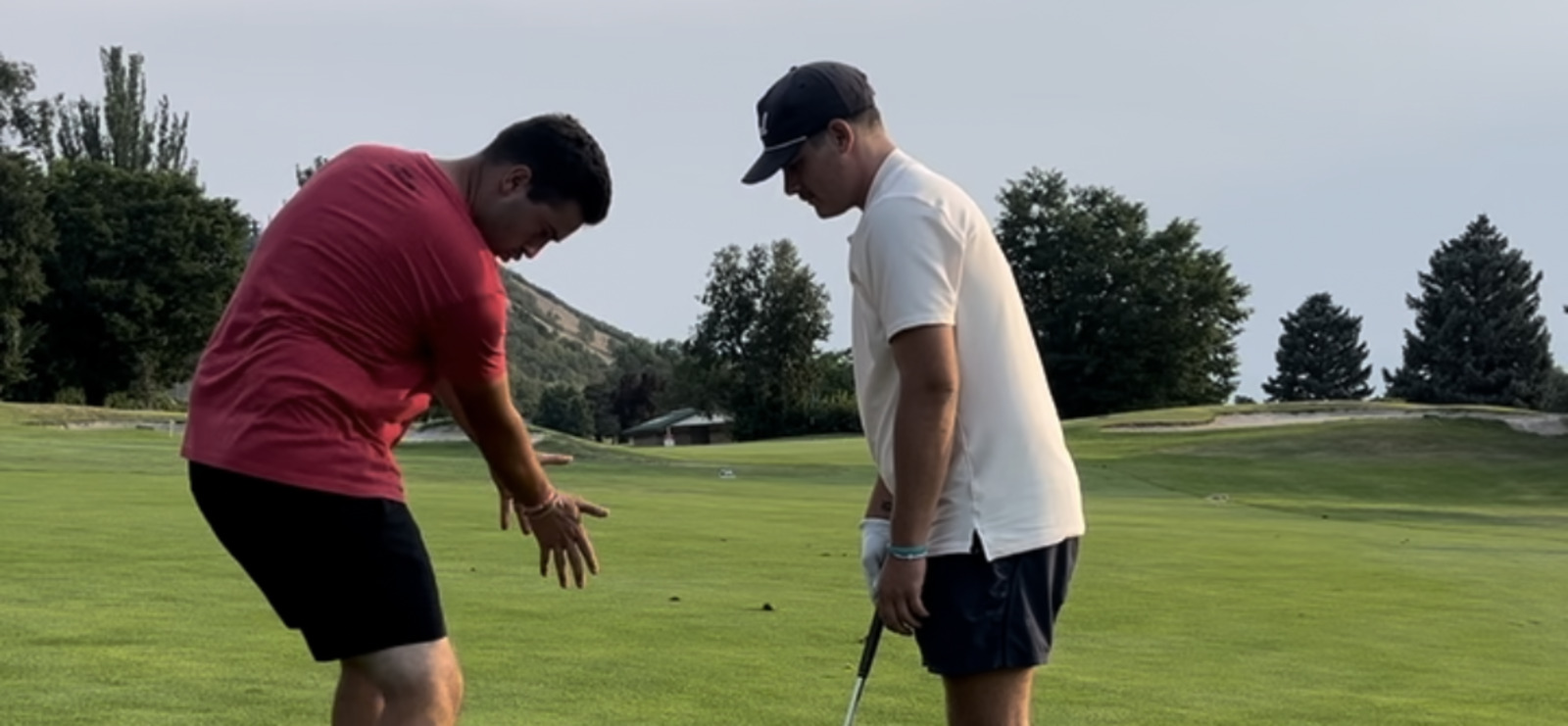 Coach Mike Yates hitting an approach shot