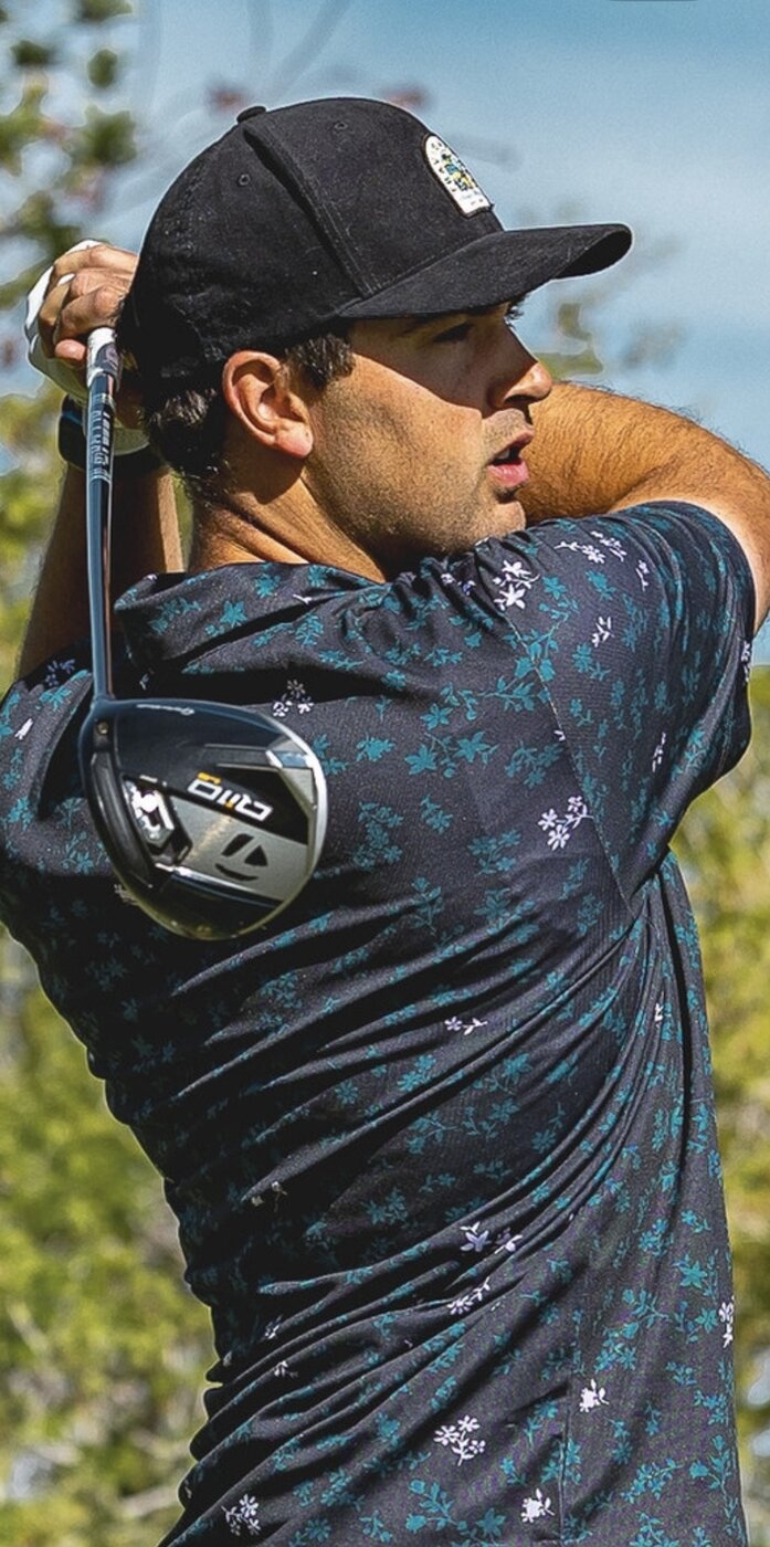 Coach Mike Yates mid-swing on a mountain golf course